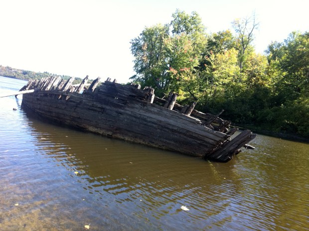 The wooden hull listed to one side in about 8 feet of water. 