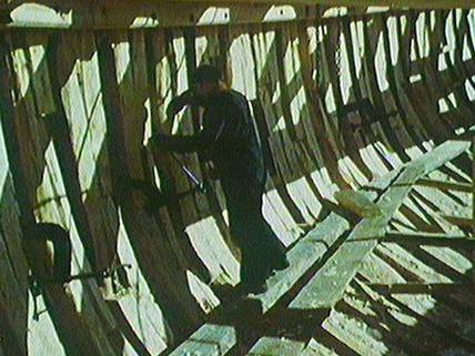 Inside the hull of the Jean Richard attaching hull planking.