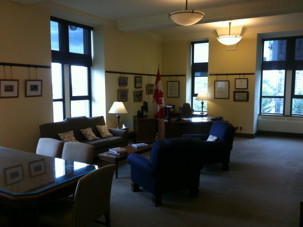 "When he was shown in through the connecting door a tall youngish man in a dark blue suit, white shirt and black tie turned away from the window and came towards him."