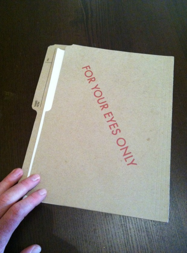 "Colonel Johns opened a drawer in the desk and took out a bulging file and opened it."