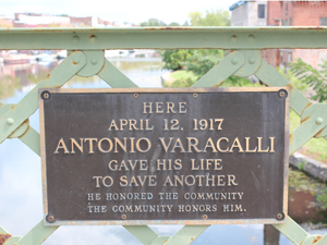 A closer photo of the plaque on the bridge indicates an incident where a man jumped into the river to save someone's life, remarkably similar to the plot point in the film where George jumps off the bridge to save the life of a drowning man. Was this incident the inspiration for Capra's film?