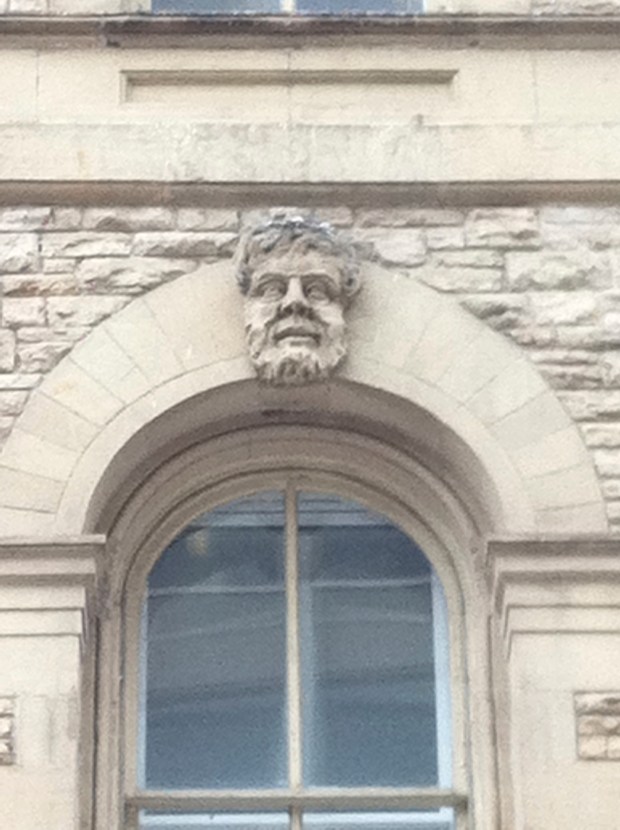The only one of the eleven carved heads on the building that has a grin.